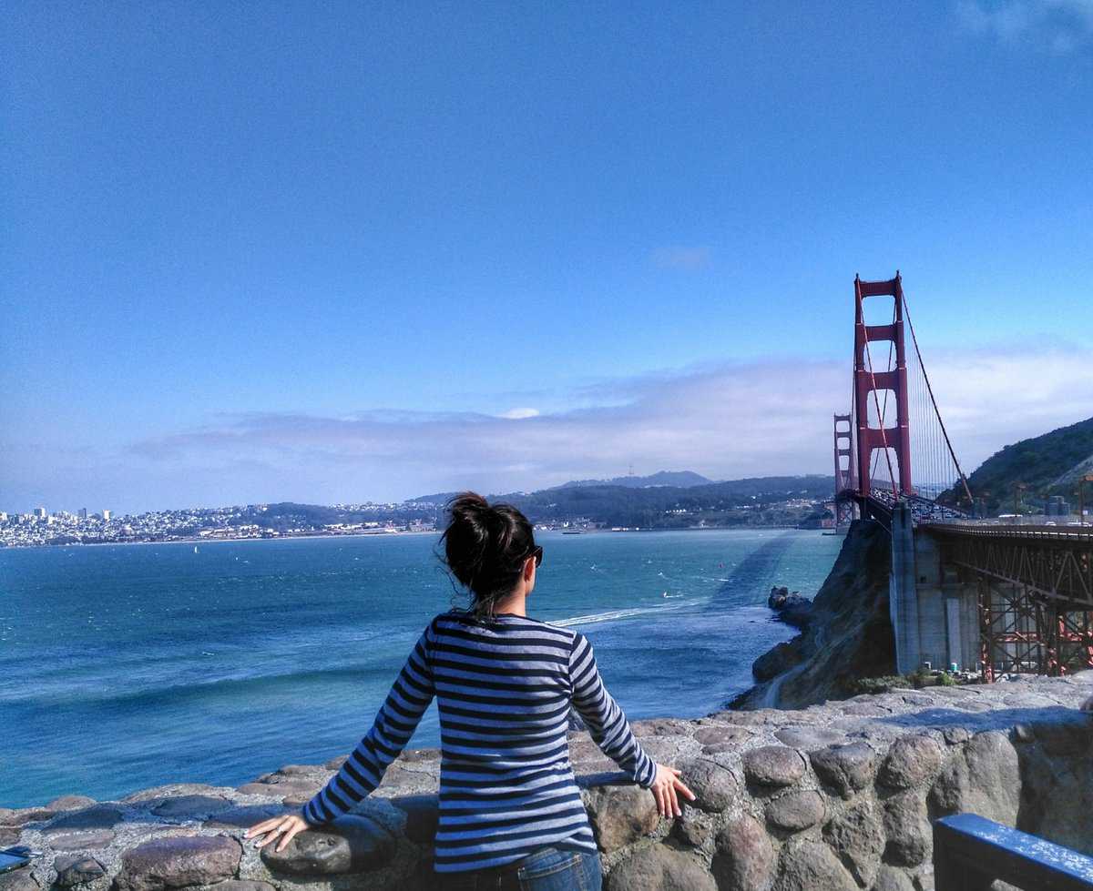 what to do in San Francisco in one day - Golden Gate Views A person in a striped shirt stands at a stone railing overlooking the Golden Gate Bridge and San Francisco Bay on a clear day.