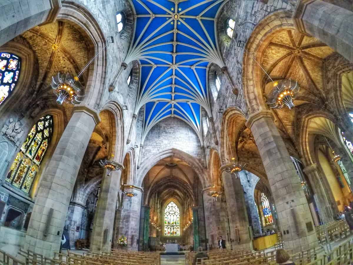 St. Giles Cathedral interior in Edinburgh, Scotland with stone arches and vibrant blue ceiling.