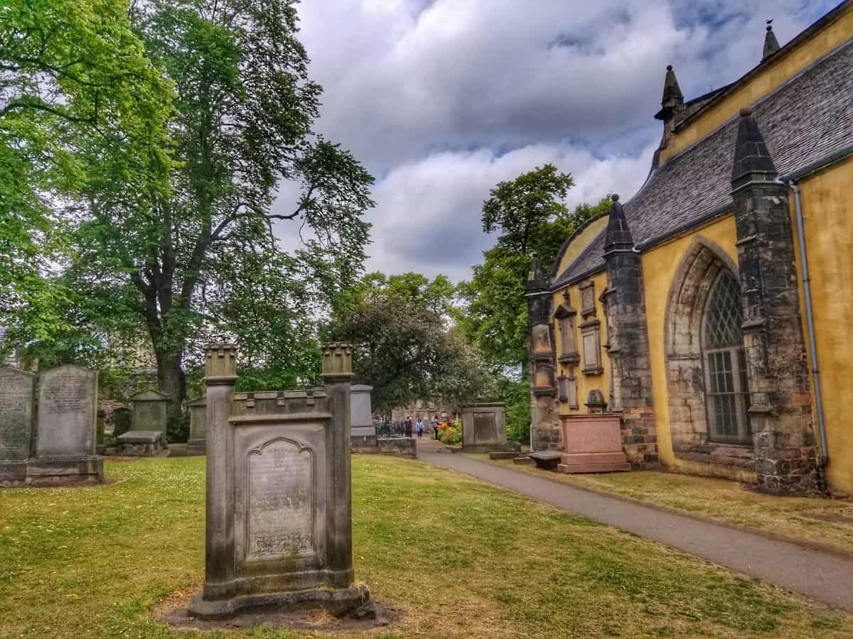 Tombstones and the historic church building at Greyfriars Kirkyard in Edinburgh, Scotland.