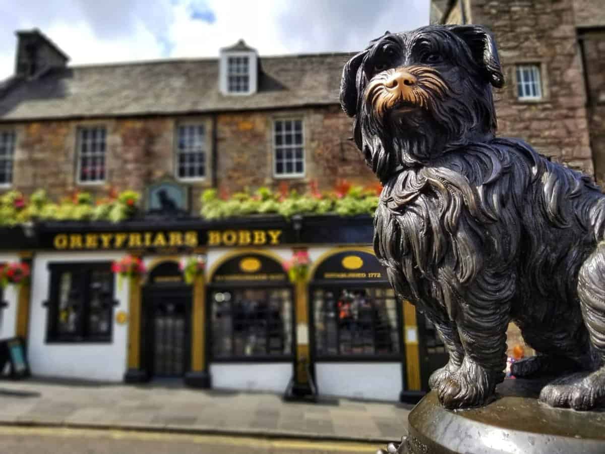 Greyfriars Bobby statue in front of Greyfriars Bobby's Bar in Edinburgh, Scotland.