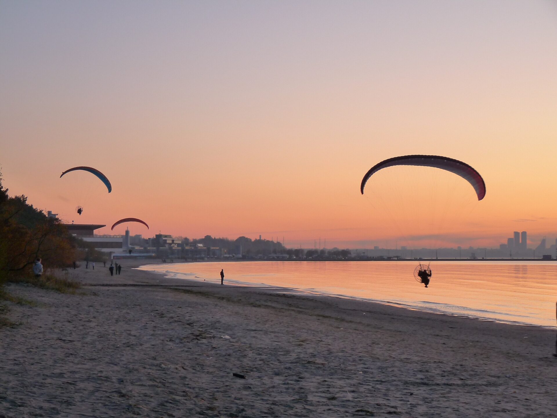 Paragliders flying at sunset over Pirita Beach in Tallinn, Estonia